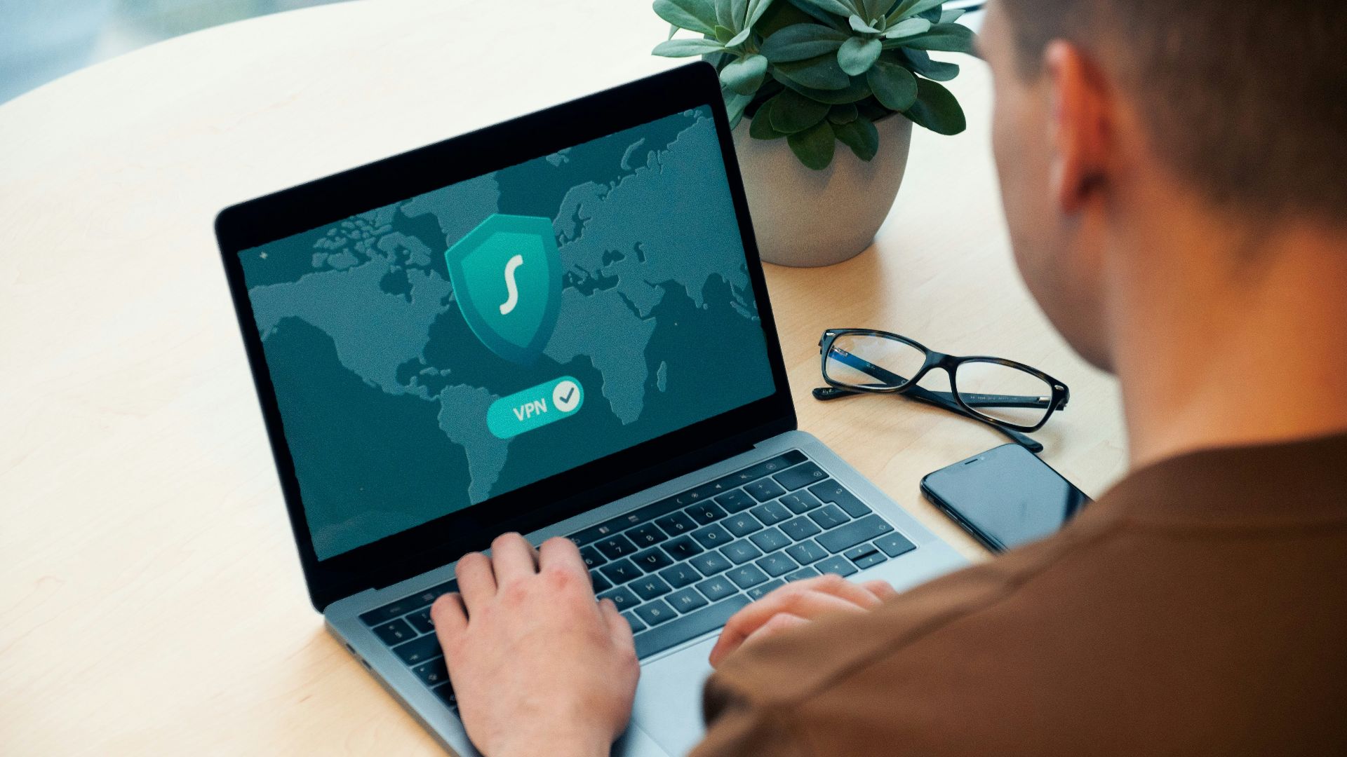 person using macbook pro on white table