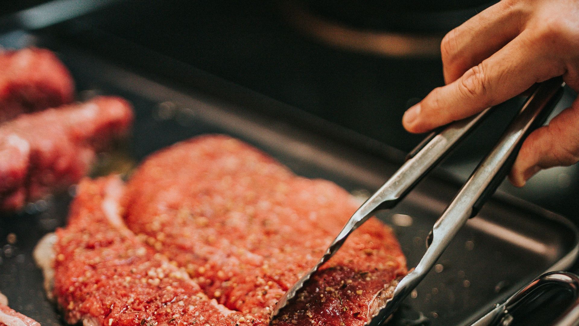 person holding stainless steel fork and steak knife
