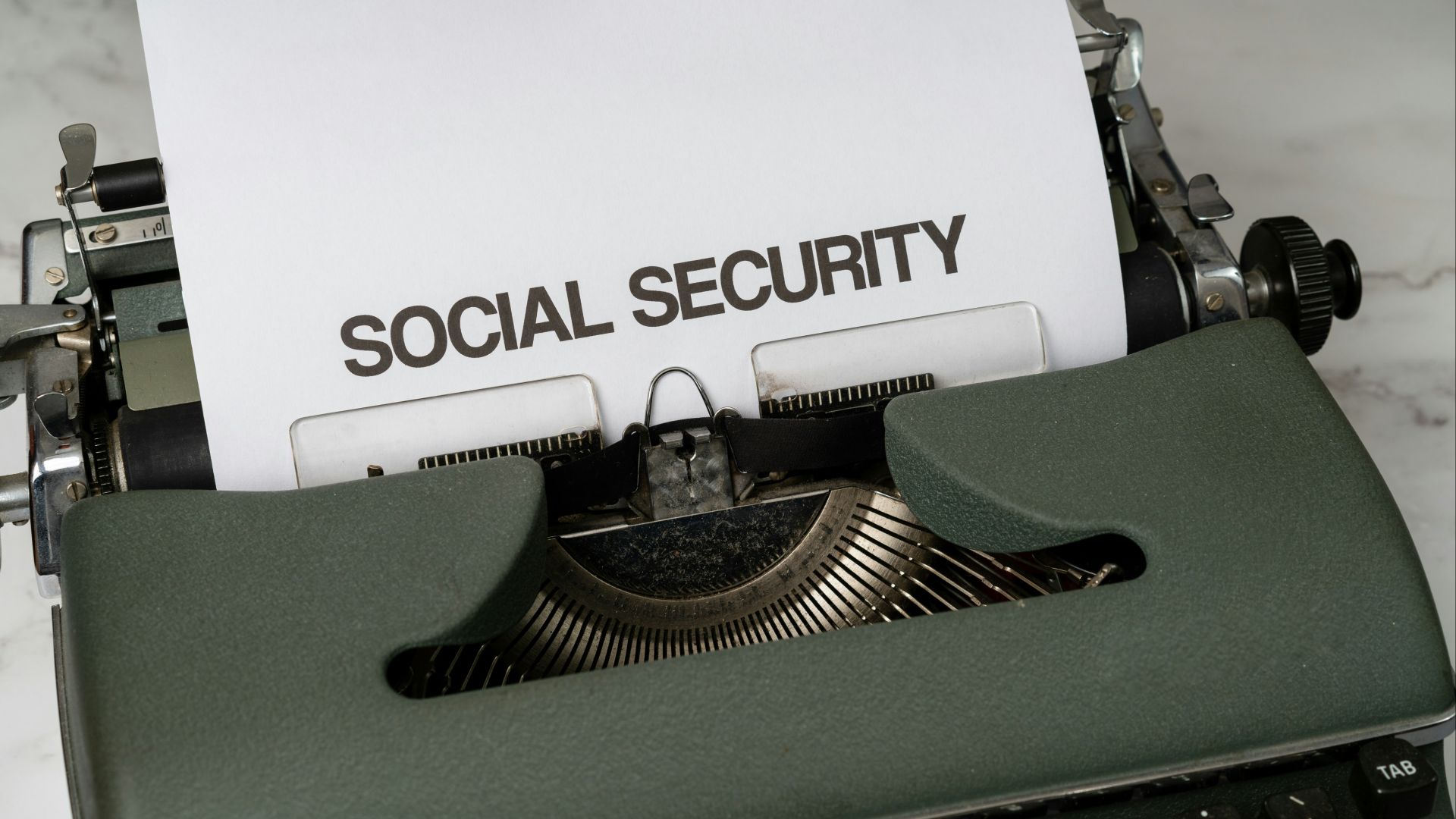 a close up of a typewriter with a paper that says social security
