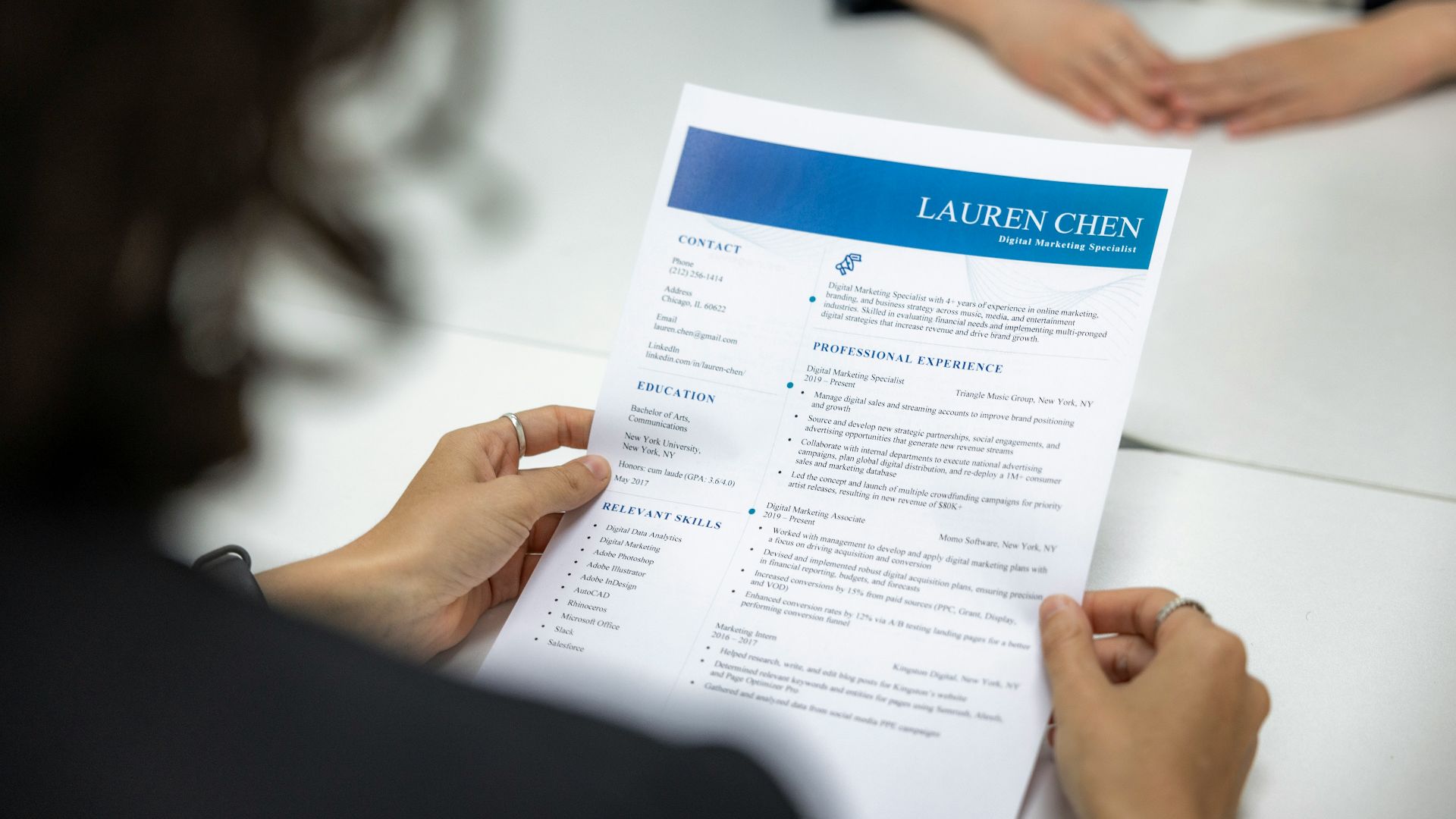 a woman is reading a resume at a table