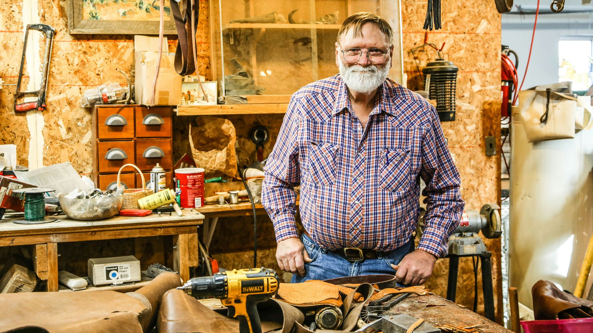 man in black and white checkered dress shirt holding black and yellow hand drill