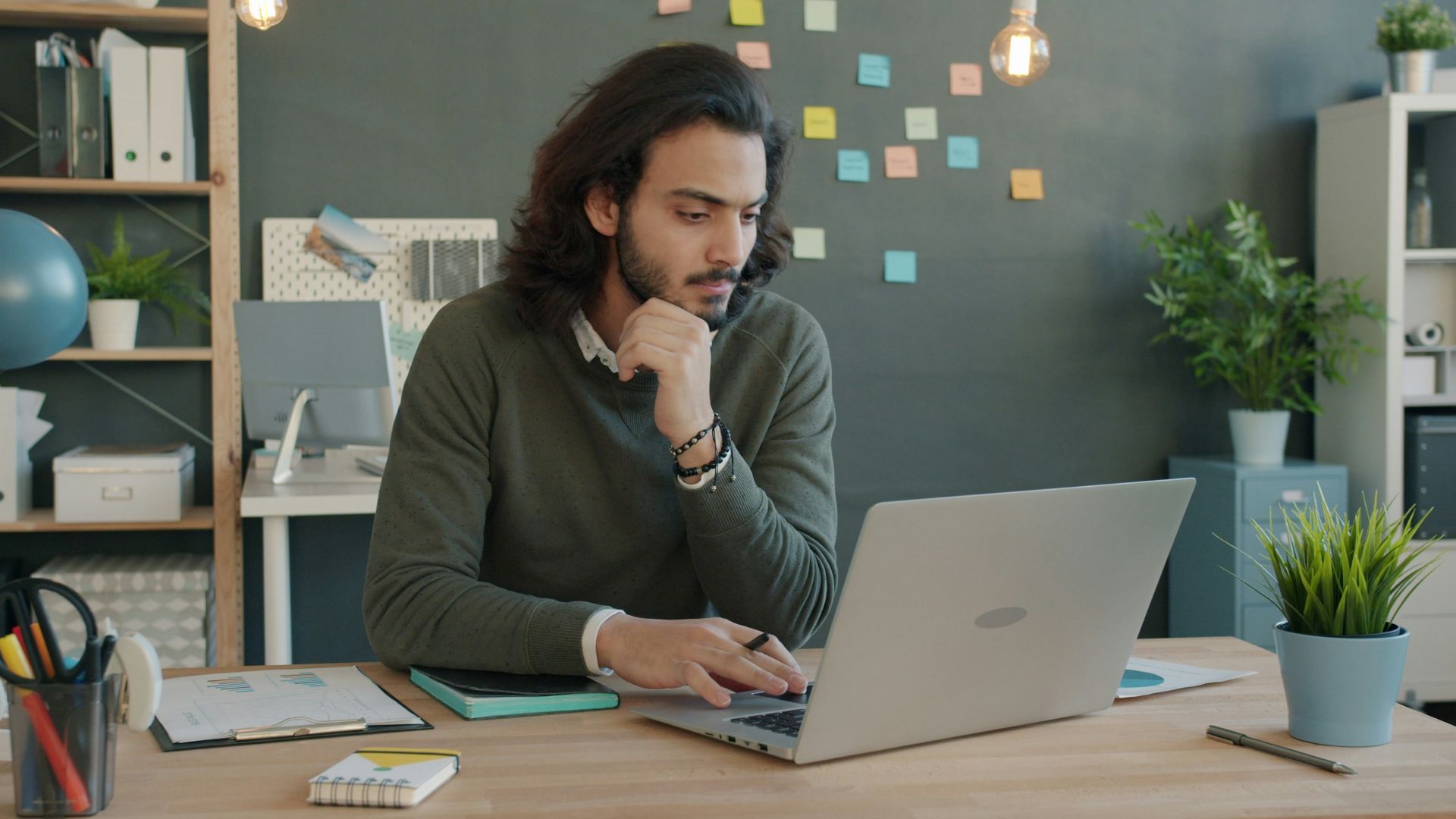 Man working on laptop in modern office space.