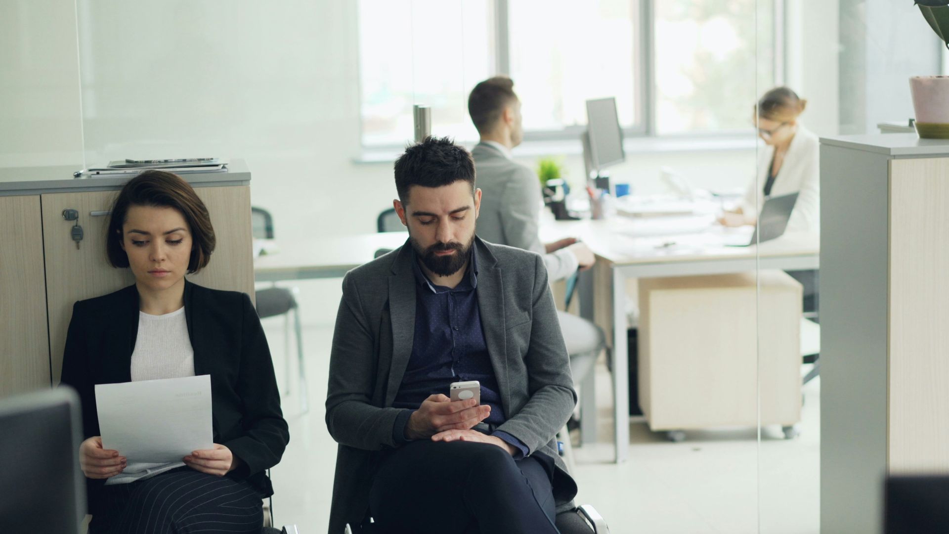 Two people waiting in an office lobby