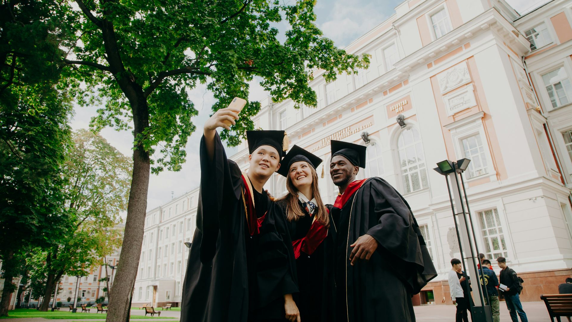 3 women in black academic dress standing near green tree during daytime