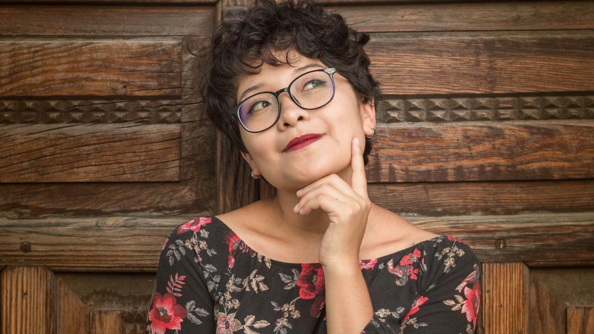 woman leaning against door while holding her cheek