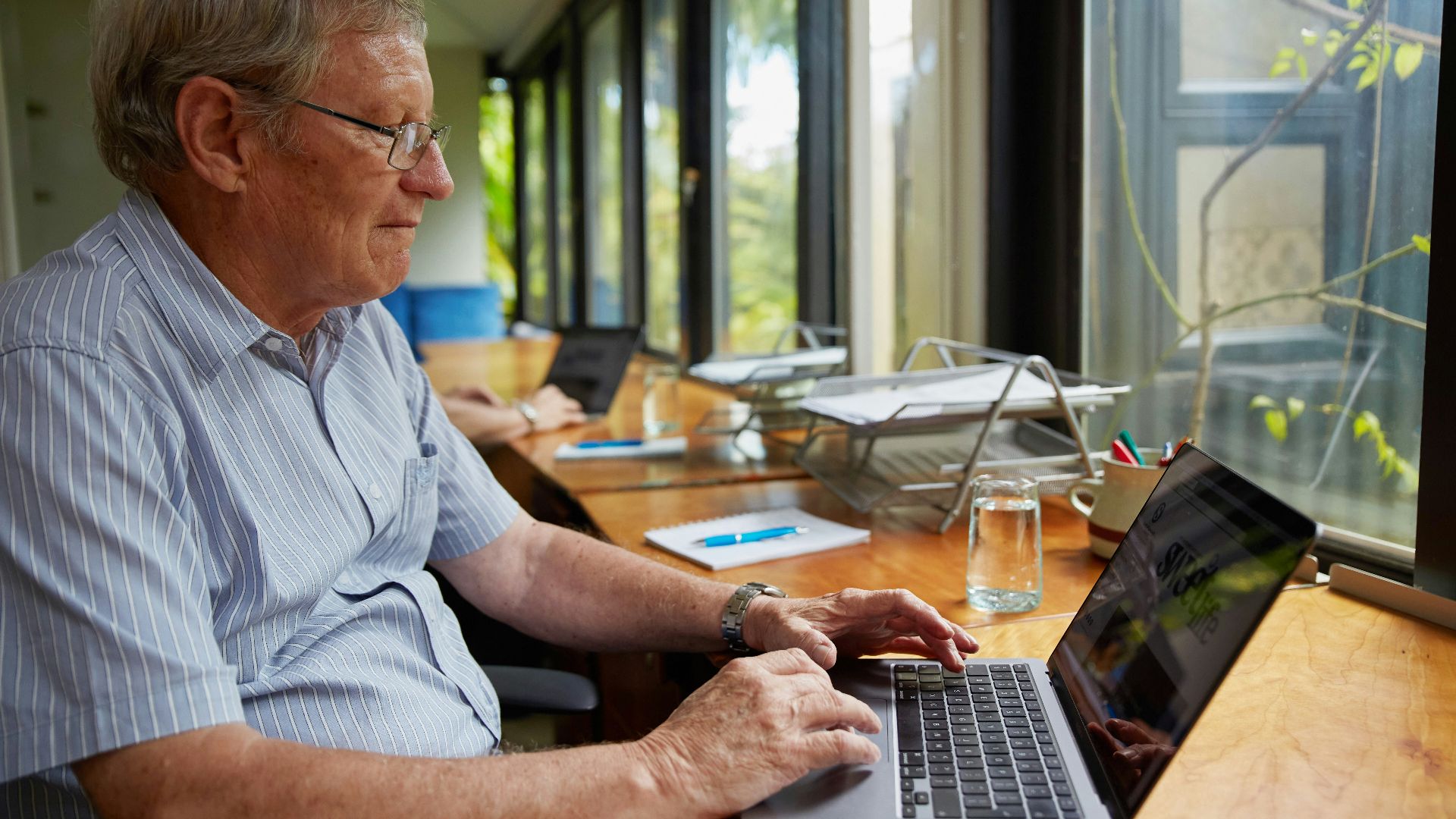 a man sitting at a table using a laptop computer