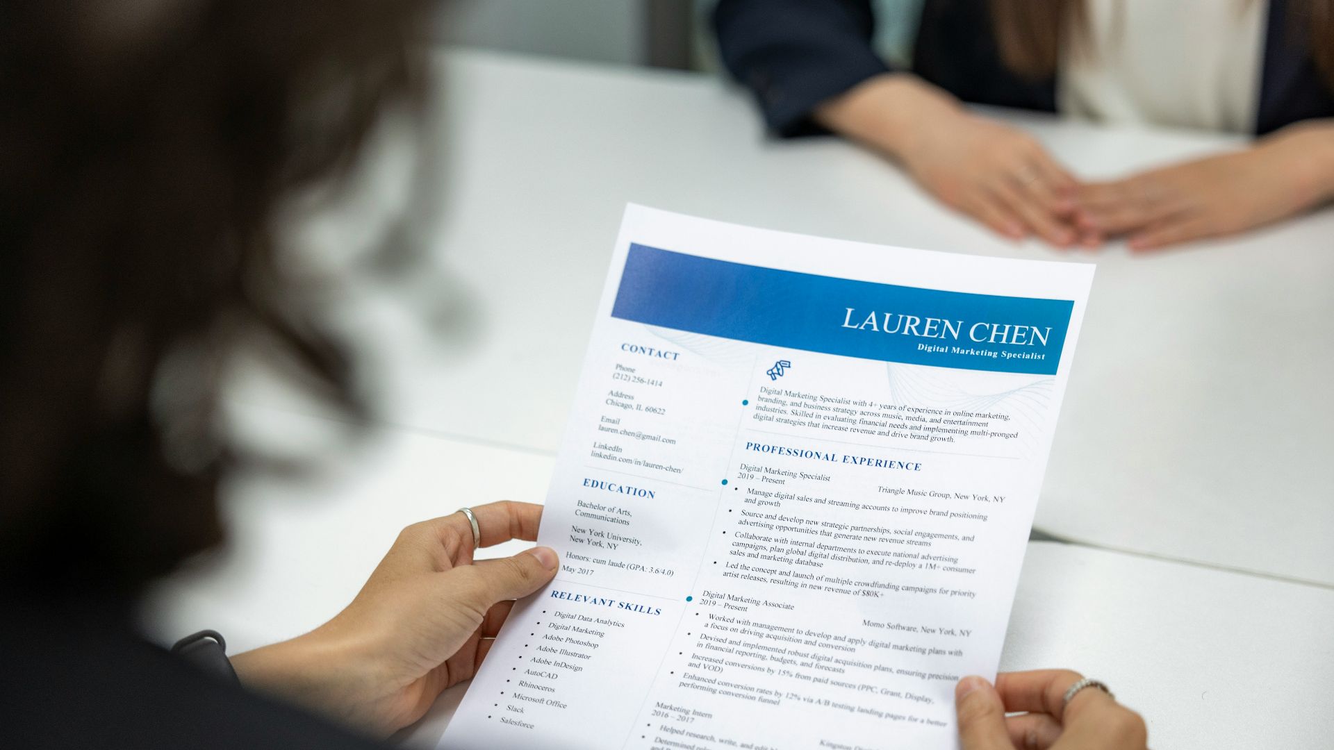 a woman is reading a resume at a table