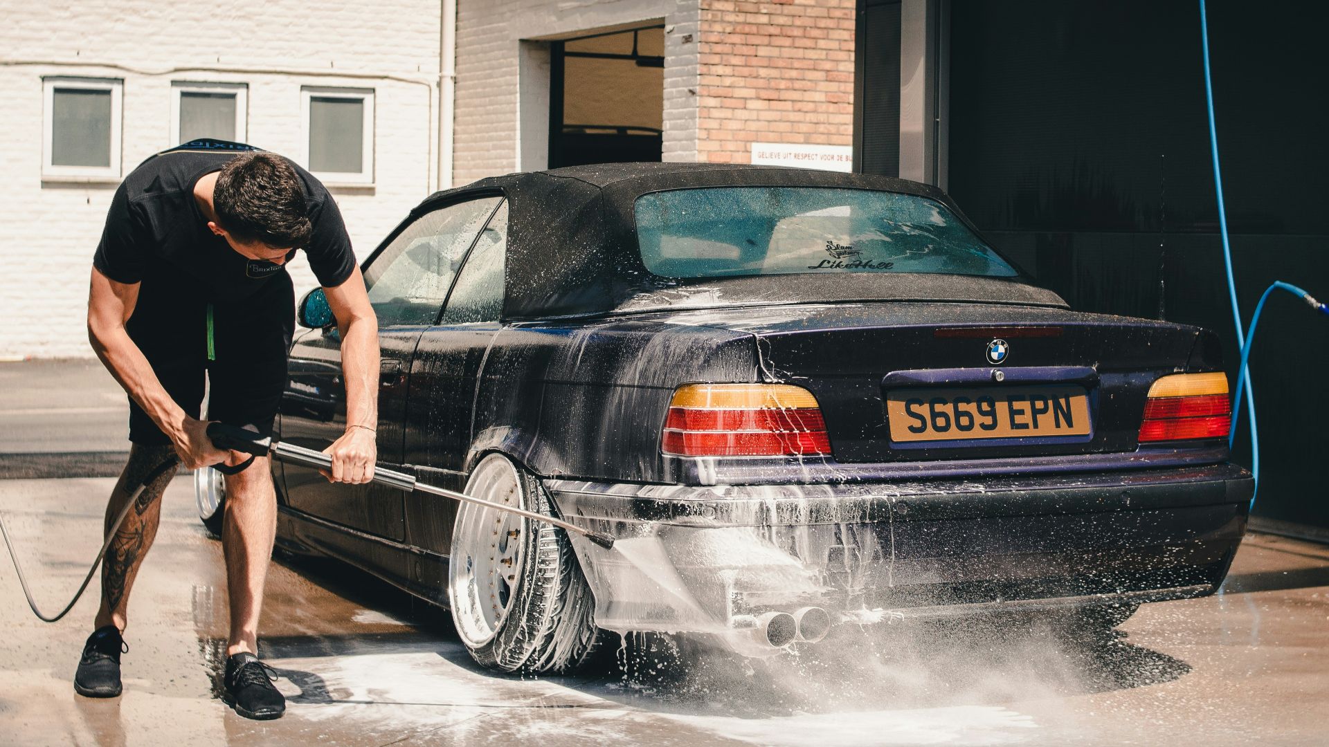 man washing BMW coupe