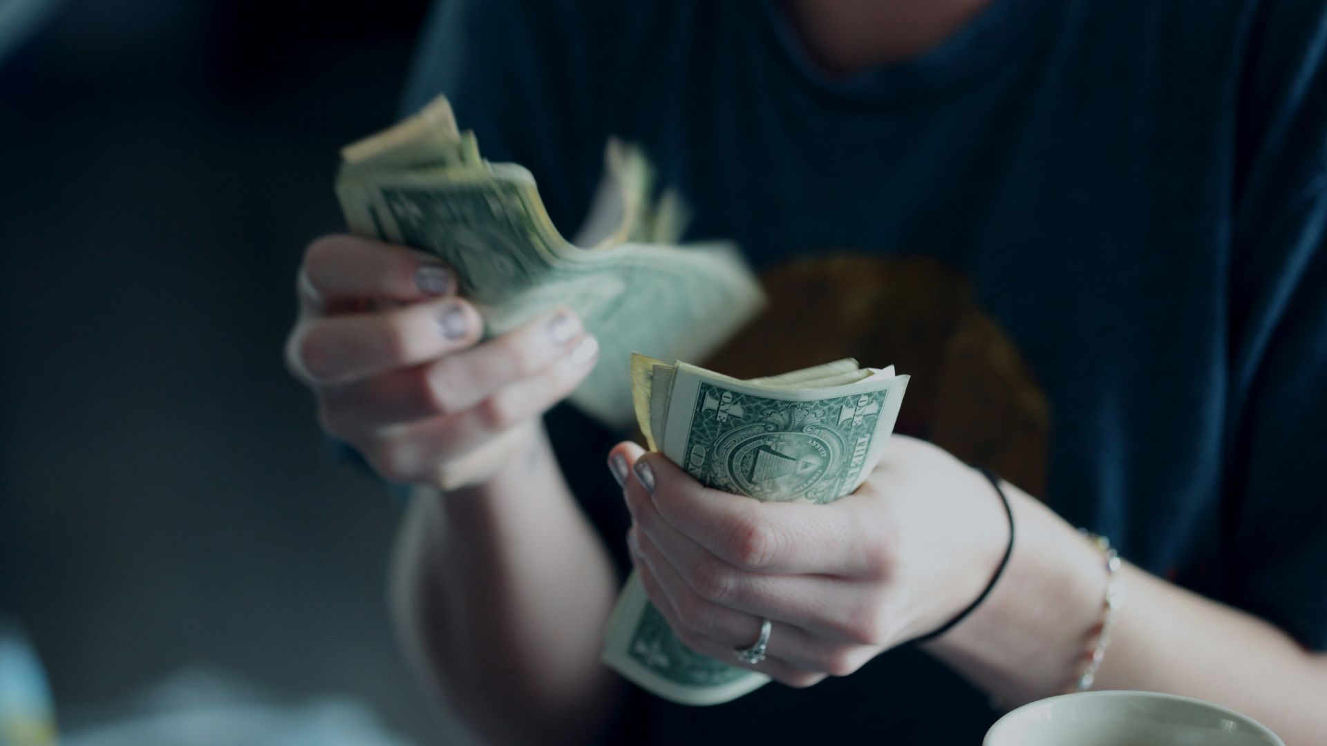 focus photography of person counting dollar banknotes