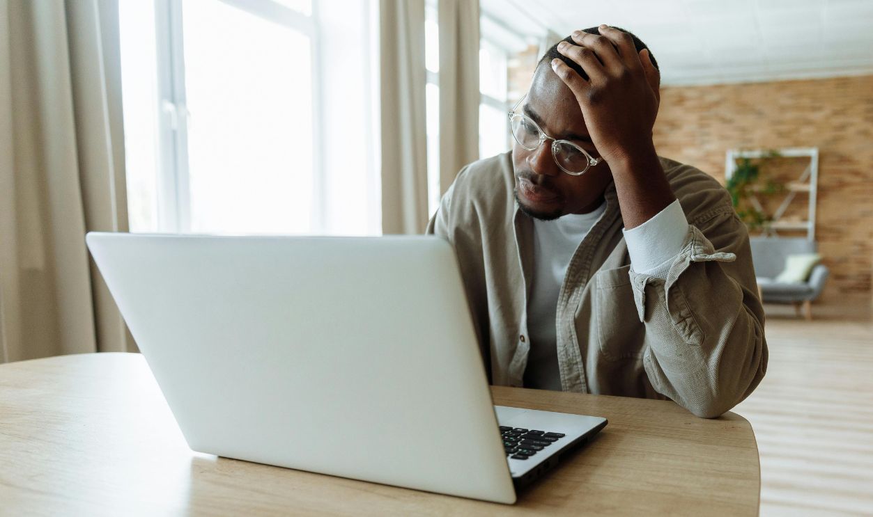 Man Using Laptop Looking Problematic