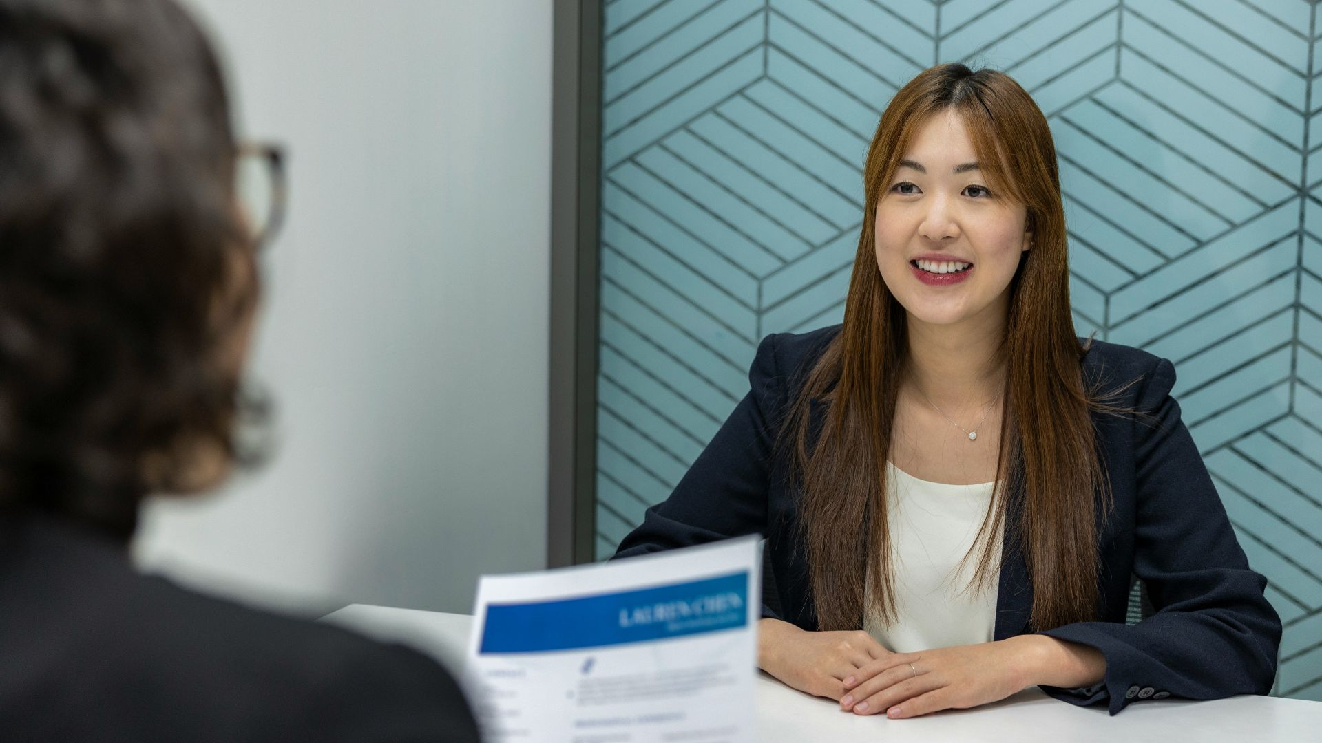 a woman sitting at a table with a piece of paper in front of her