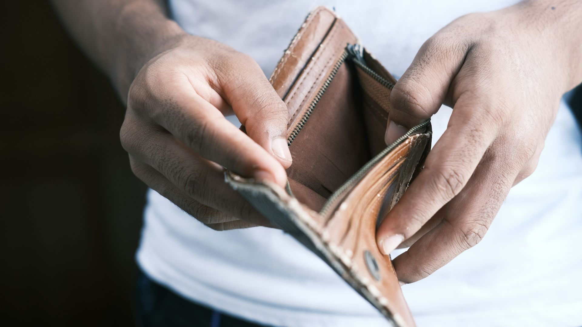 person holding brown leather bifold wallet