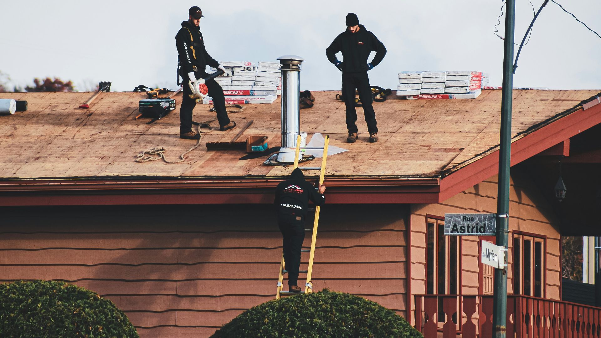 a couple of men standing on top of a roof