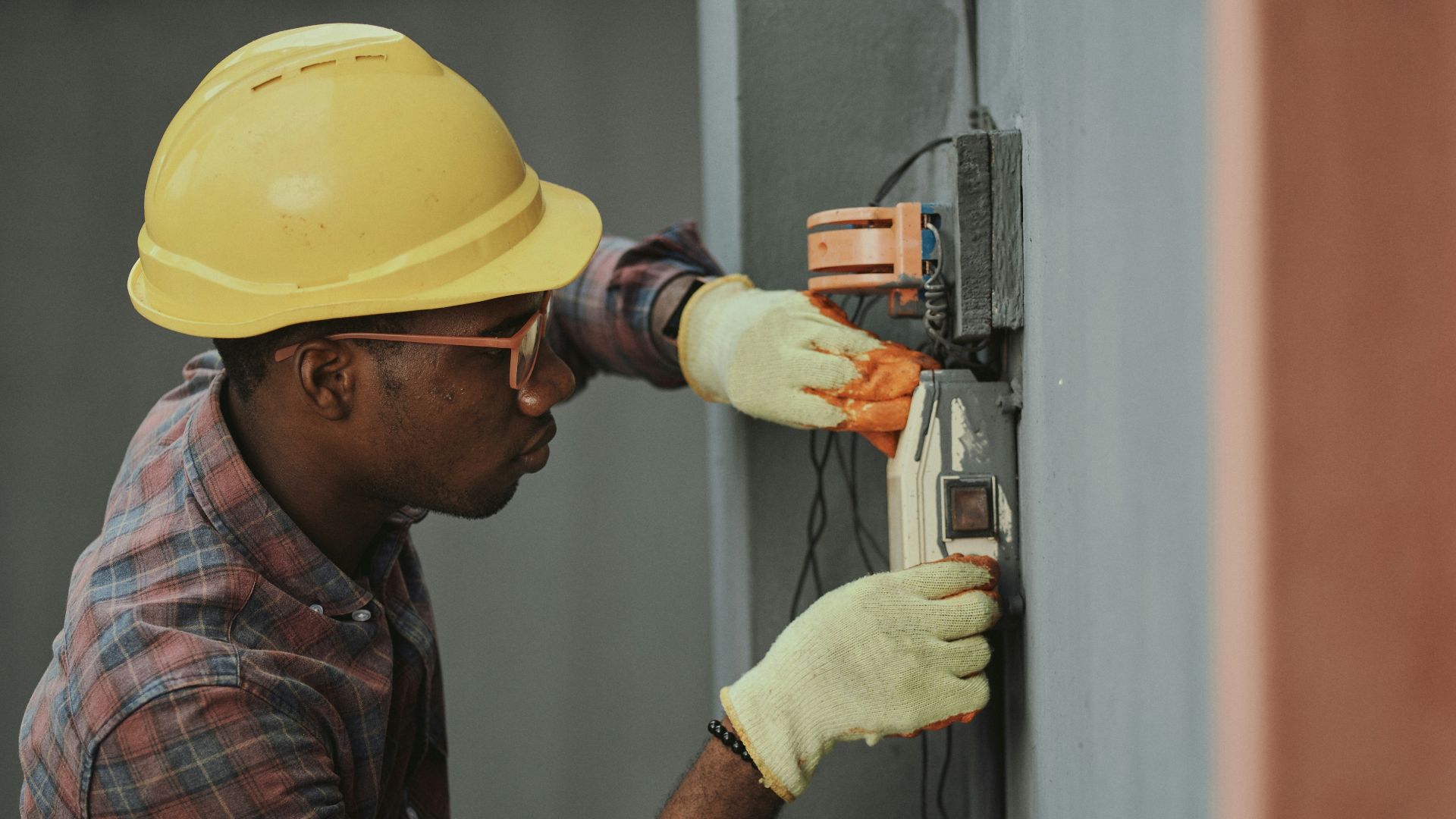 man in brown hat holding black and gray power tool
