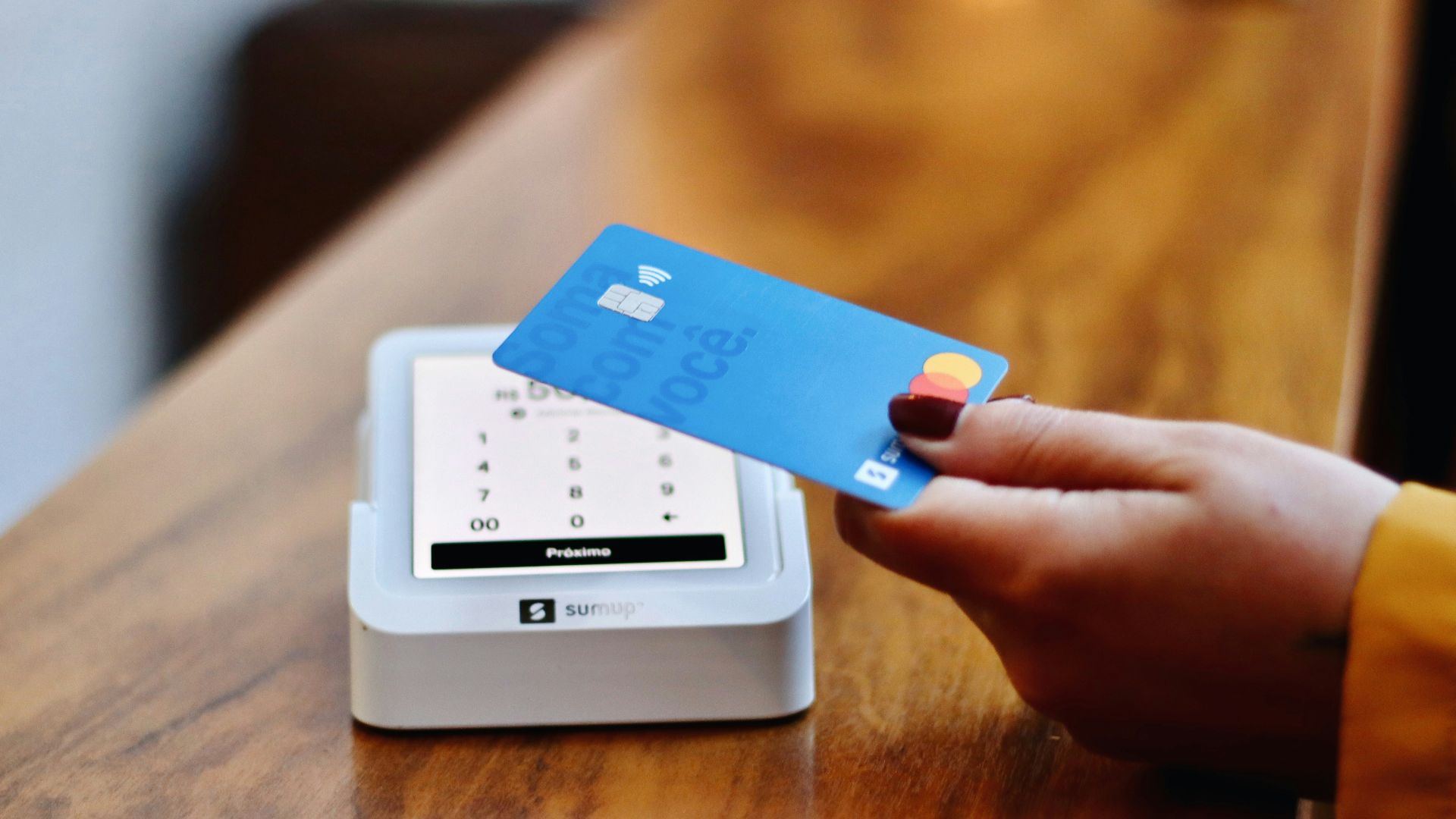a person holding a credit card in front of a machine