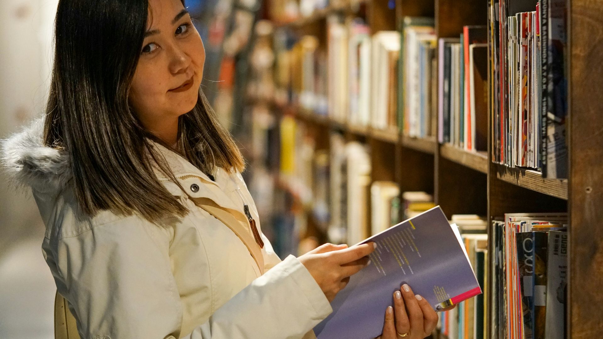 a woman looking at a book in a library