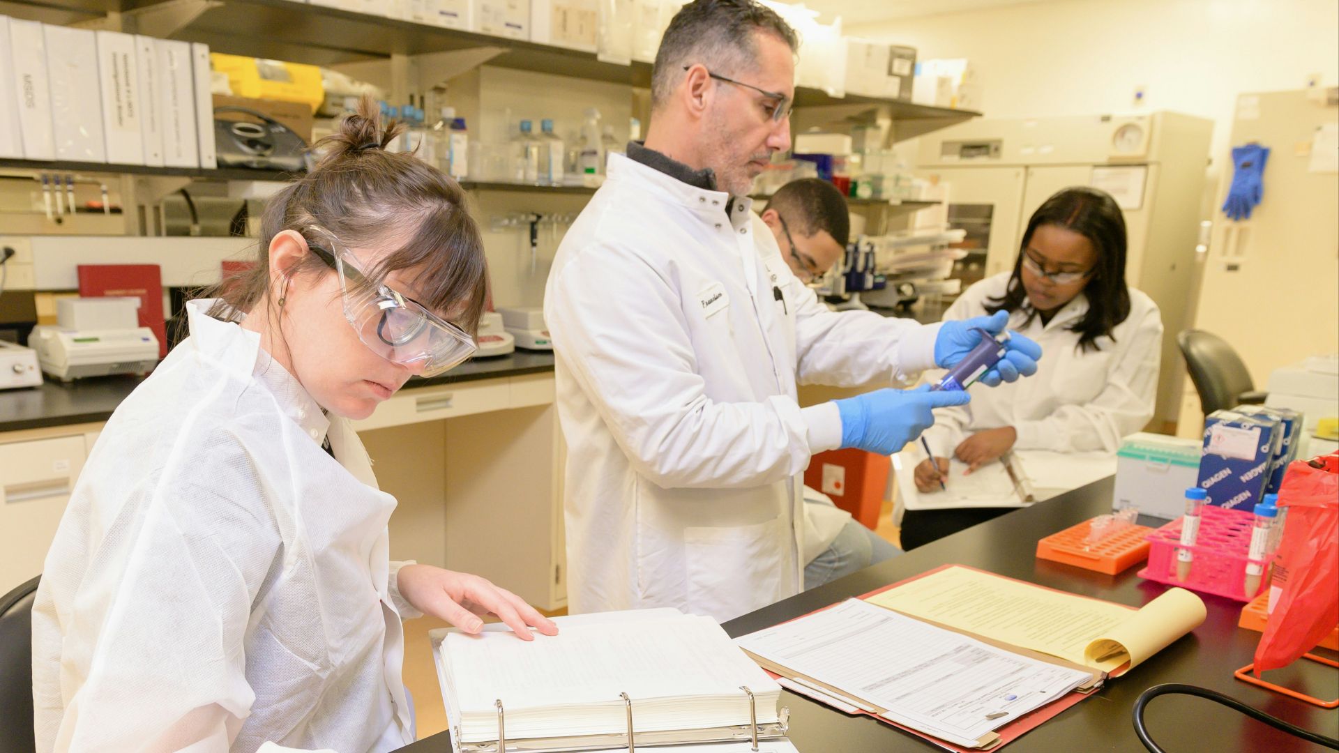 a group of people in lab coats working in a lab