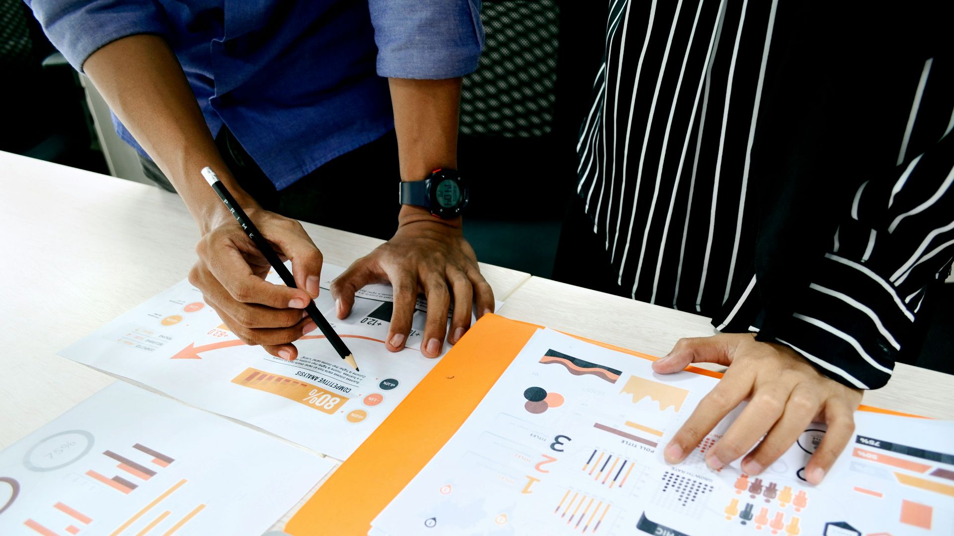 person in blue shirt writing on white paper