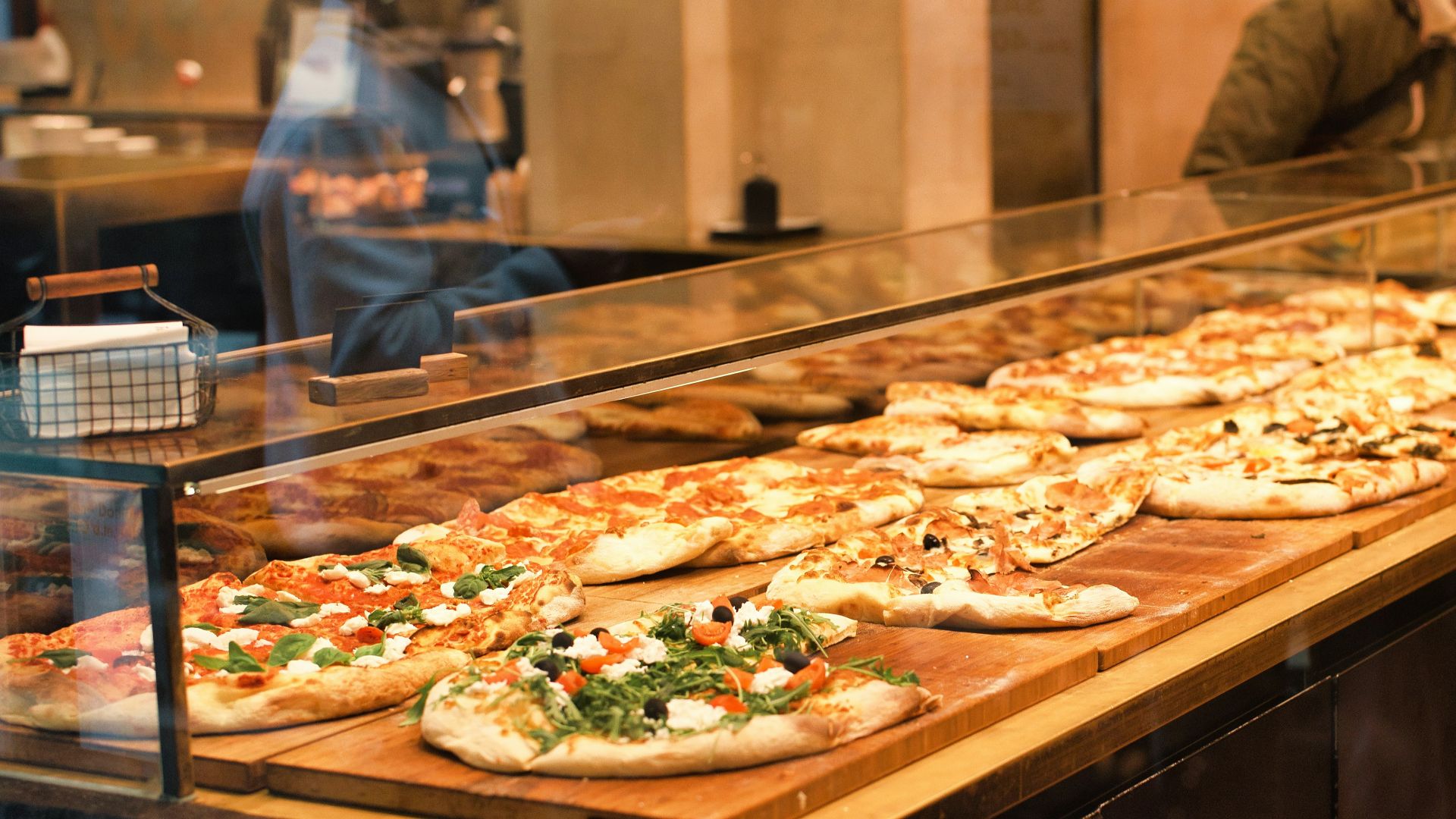 a display case filled with lots of pizzas