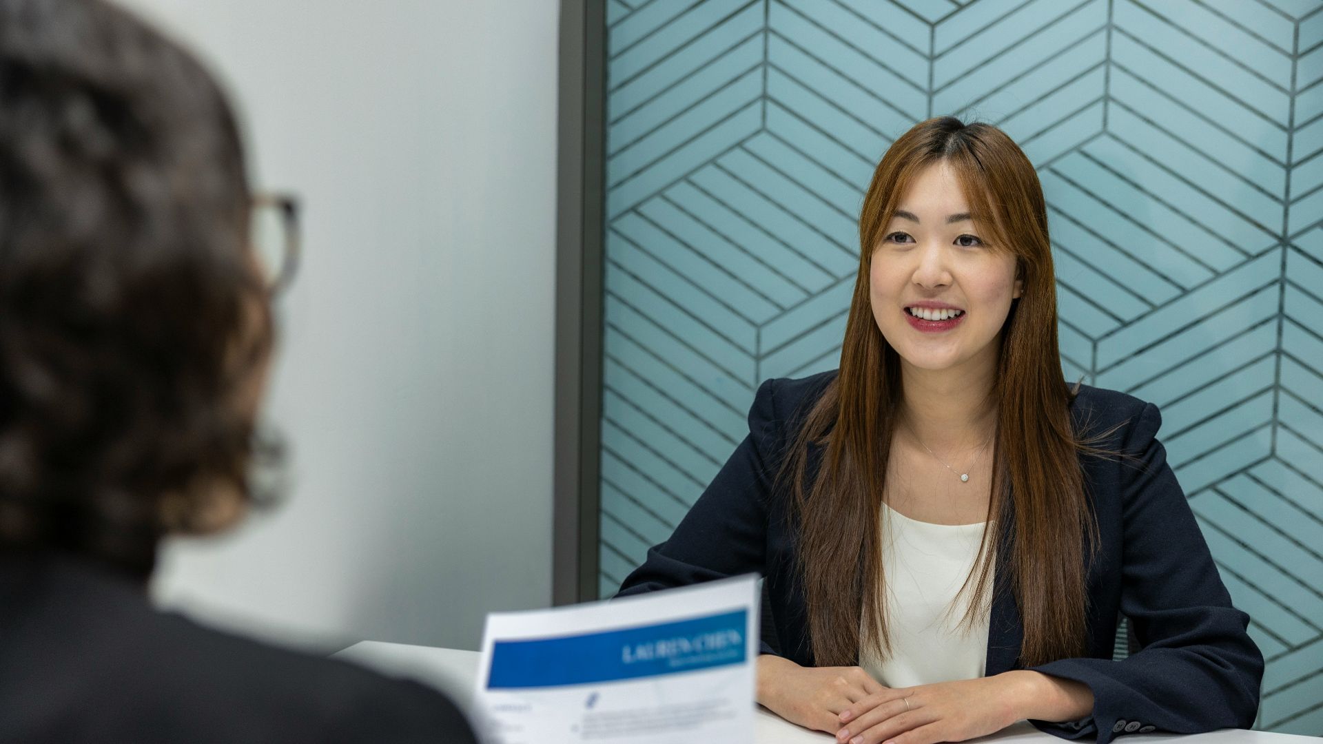 a woman sitting at a table with a piece of paper in front of her
