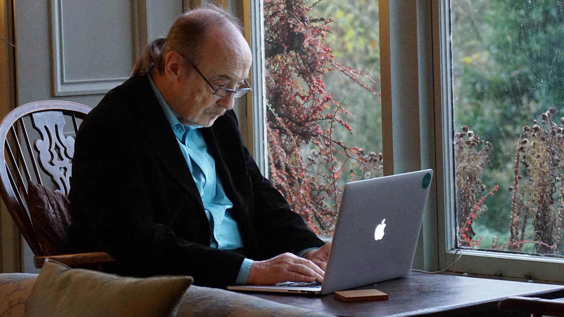 man in black suit jacket using macbook