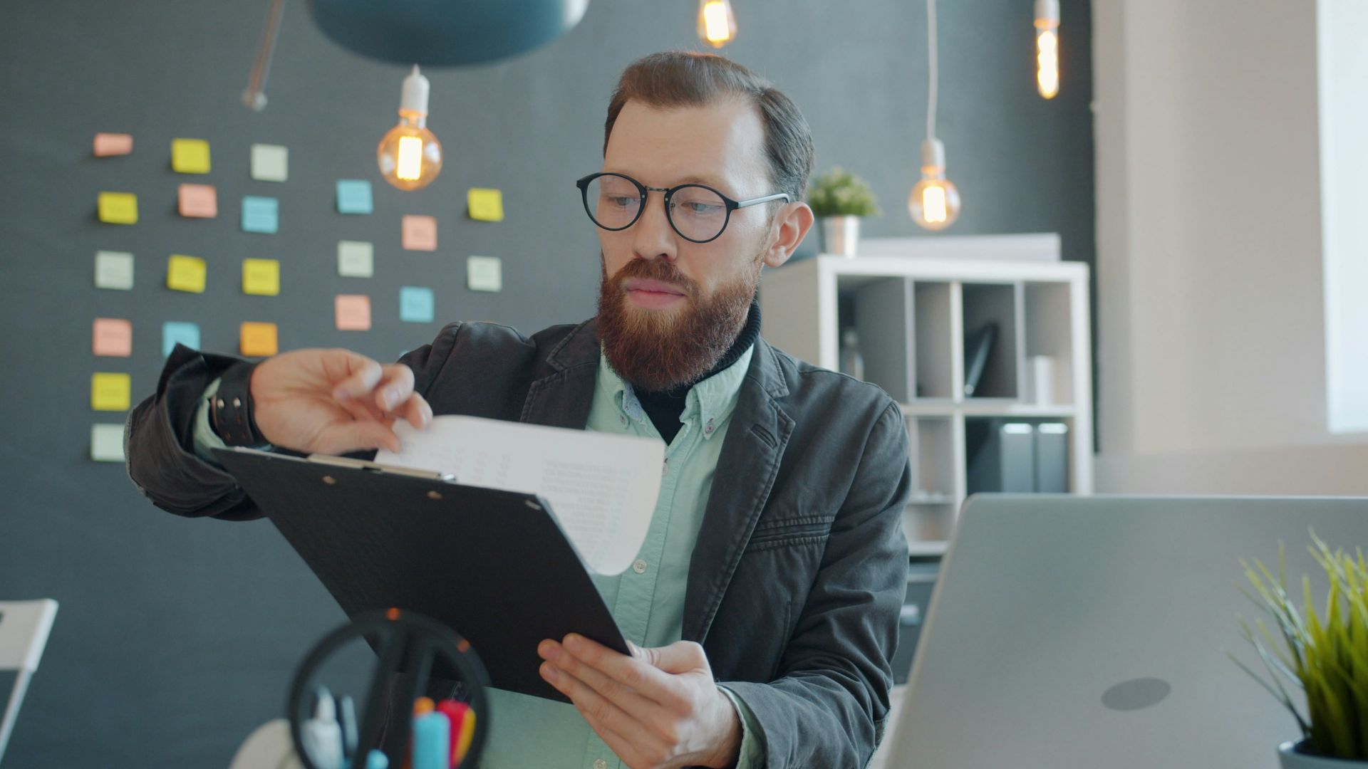 Man in glasses reviewing documents at desk