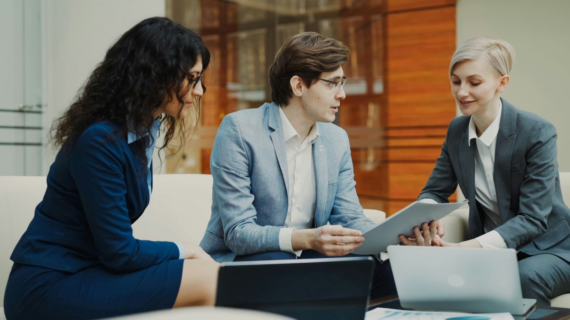 Three professionals discussing documents at a table.