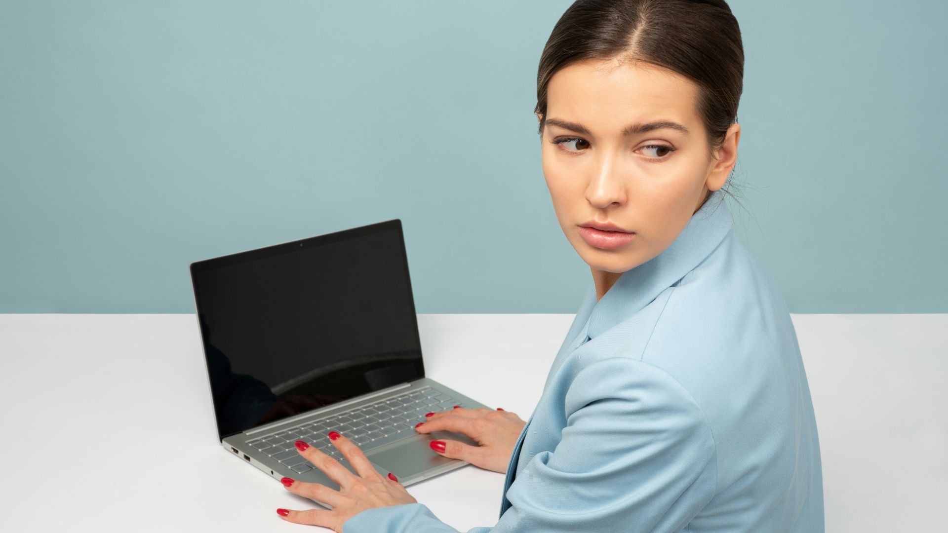 woman using laptop and looking side