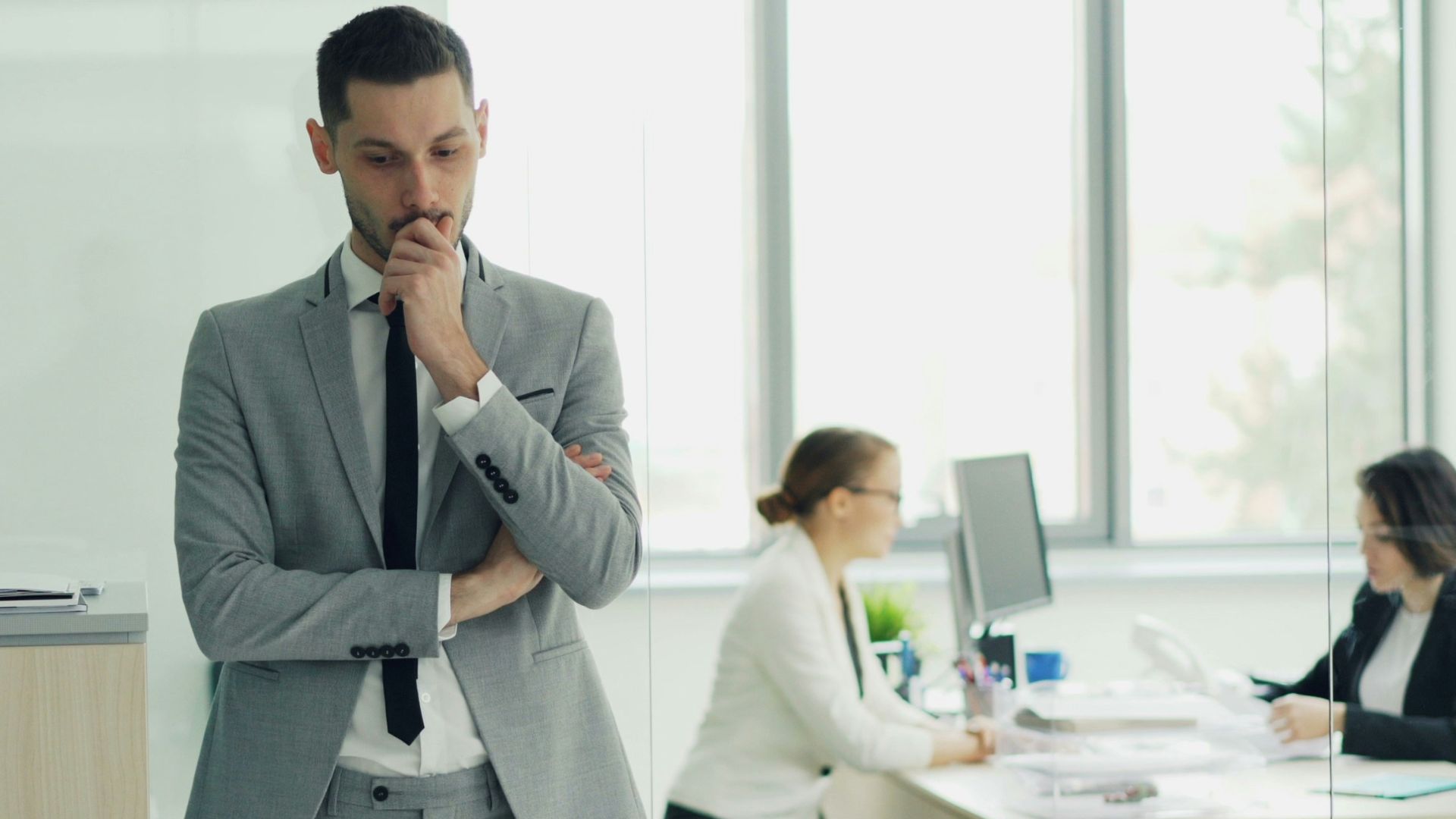Man in suit thinking in modern office environment