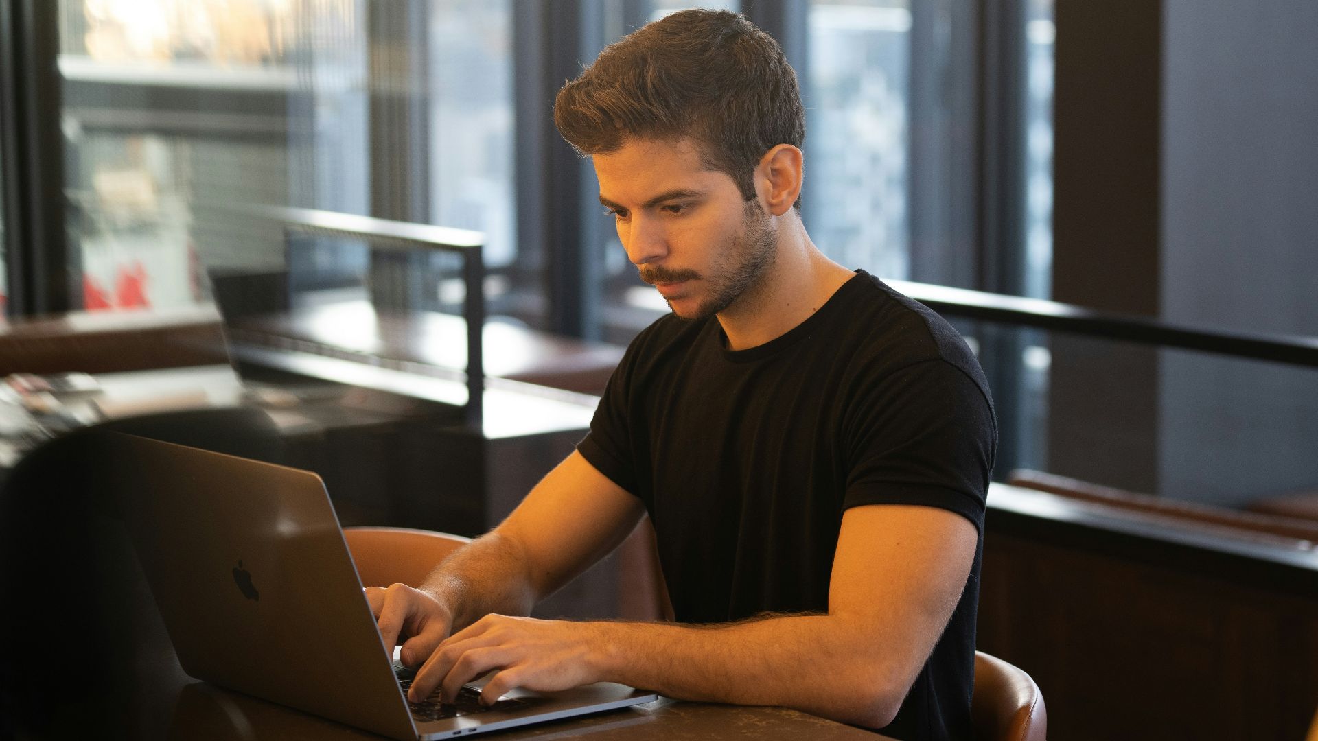 man in black crew neck t-shirt using macbook