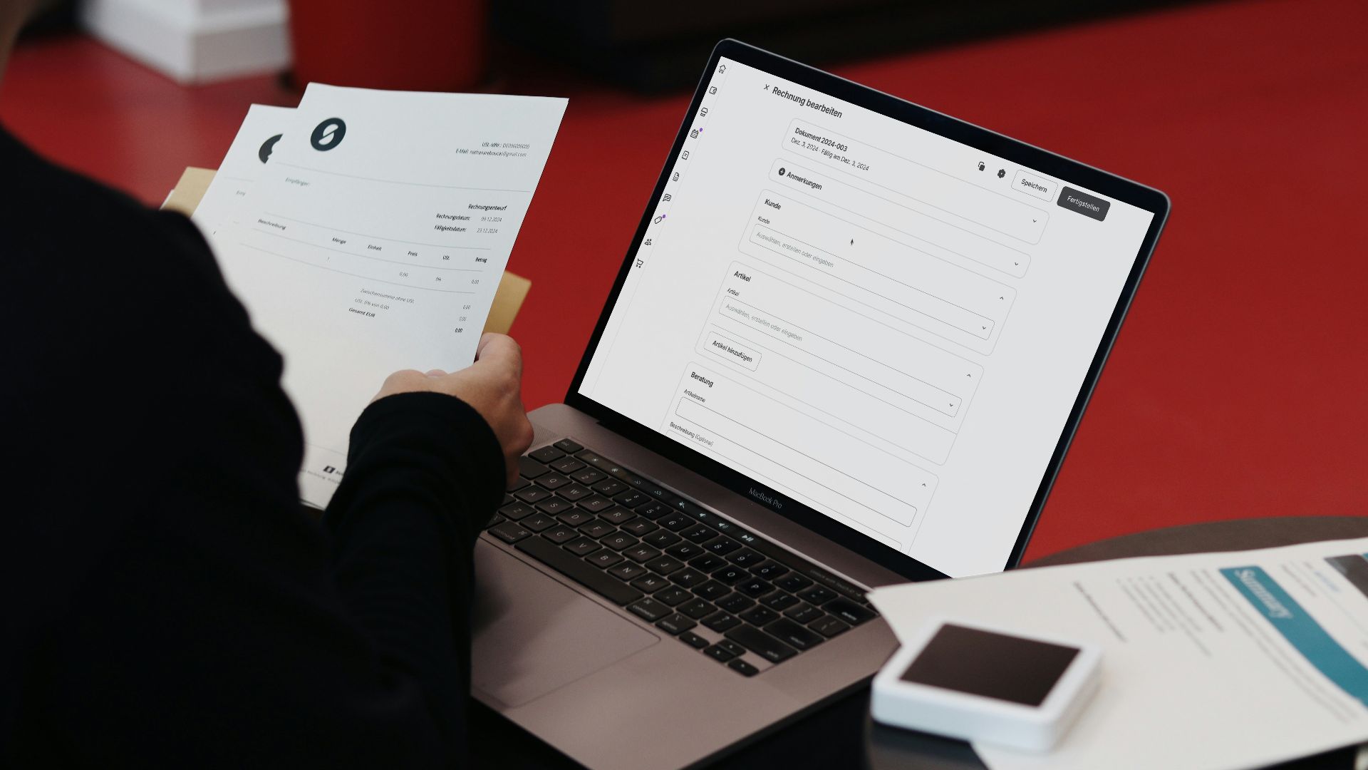 A person sitting at a desk with a laptop and papers