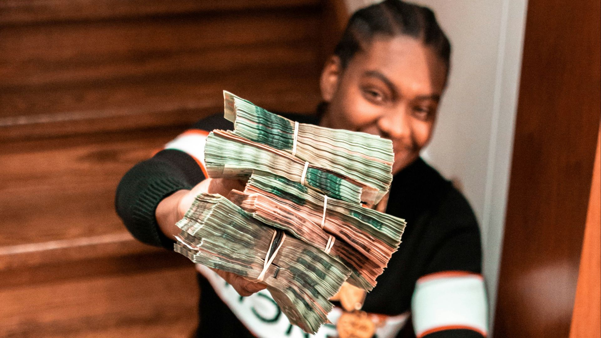 woman in black long sleeve shirt and blue denim jeans sitting on brown wooden stairs