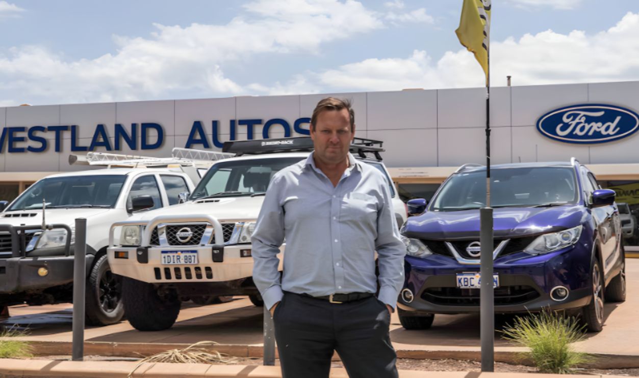 Man standing in front of a Ford Dealership