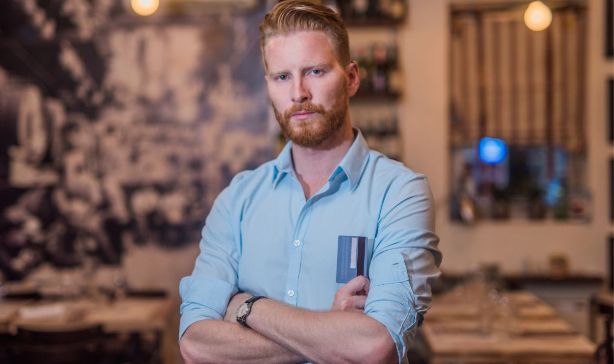 898256822-Portrait of a young man with a credit card in the bar