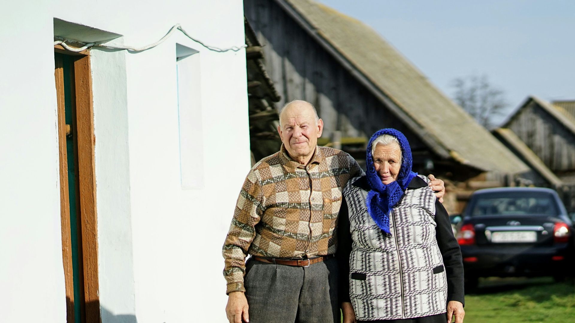 man and woman standing beside building and near cars