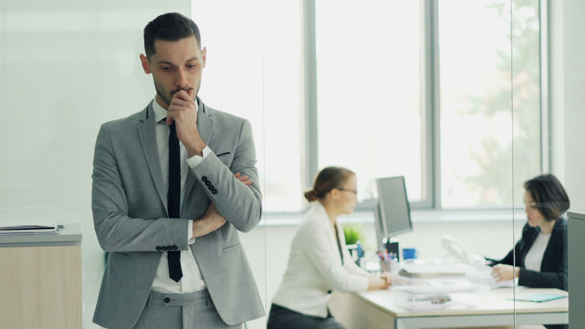 Man in suit thinking in modern office environment