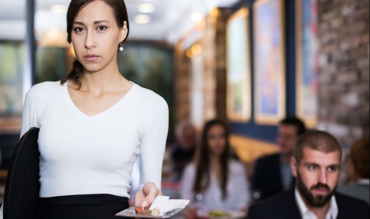1859768833 -BearFotos- Portrait of employee waitress with serving tray with tips indoors