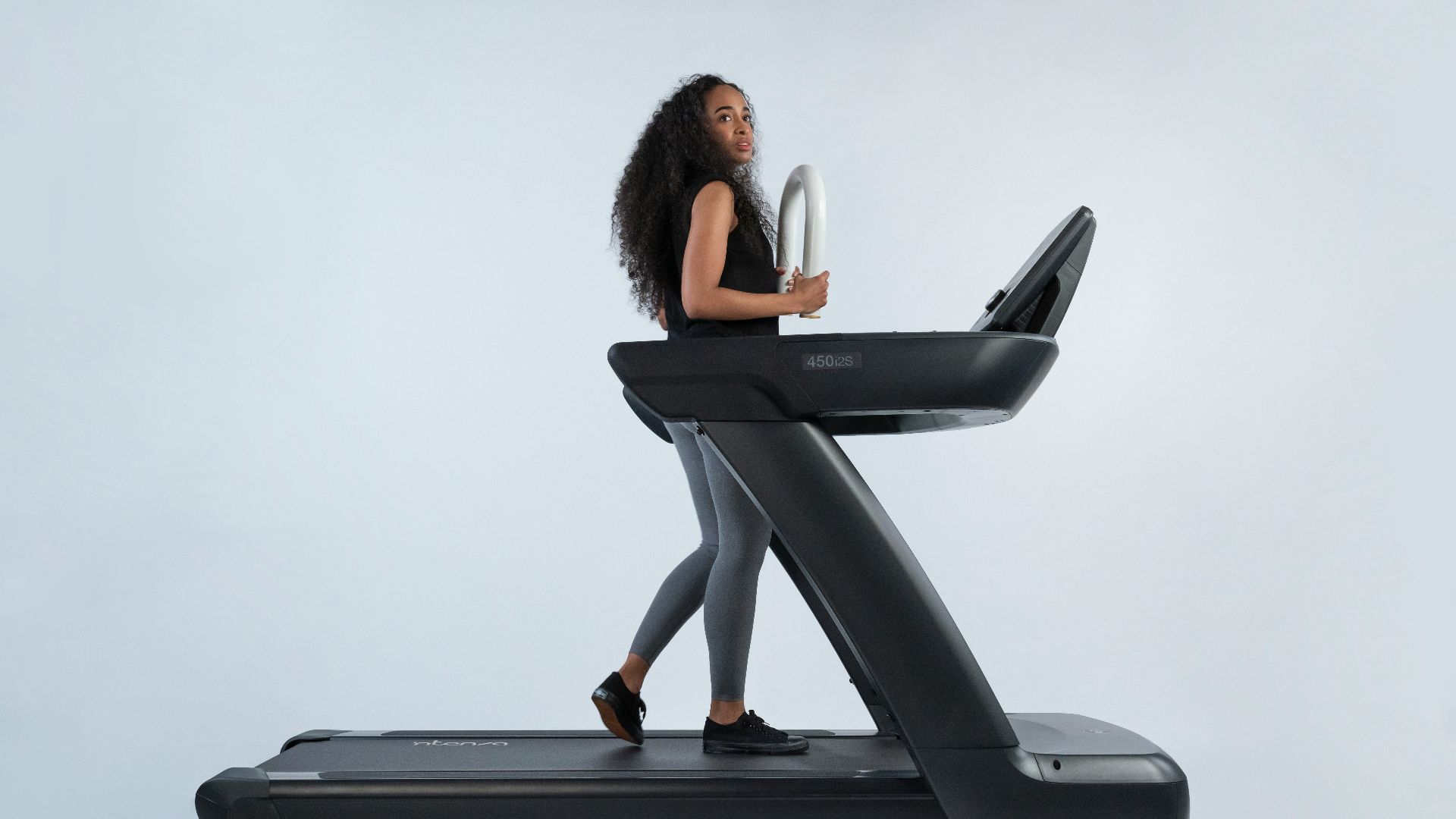 a woman is walking on a treadmill