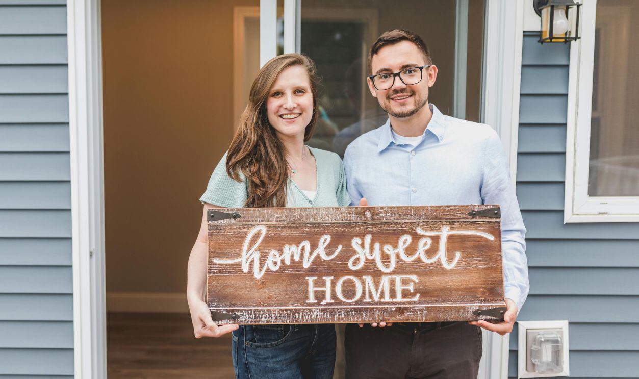 Couple Holding a Wooden Home