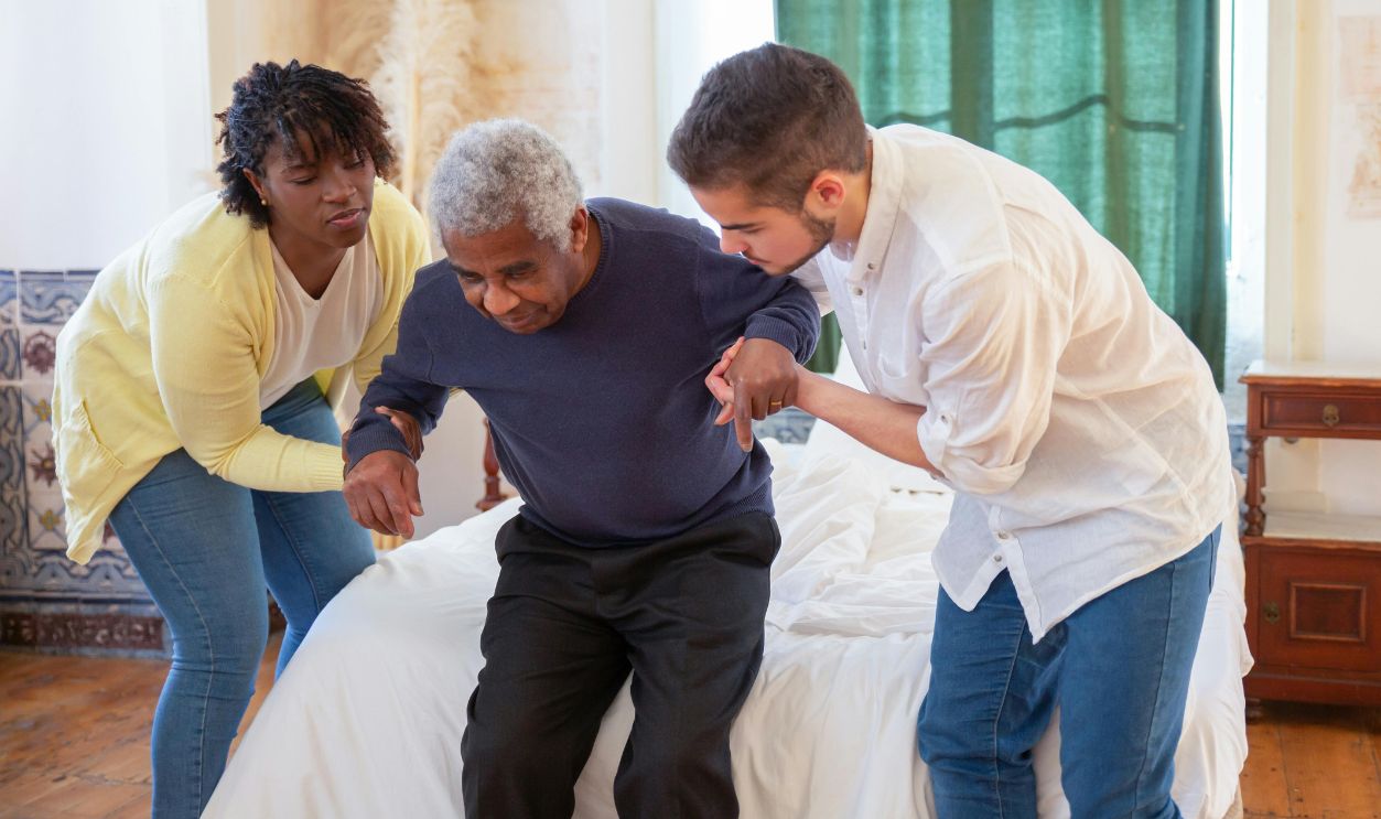 Caregivers assiting elderly man