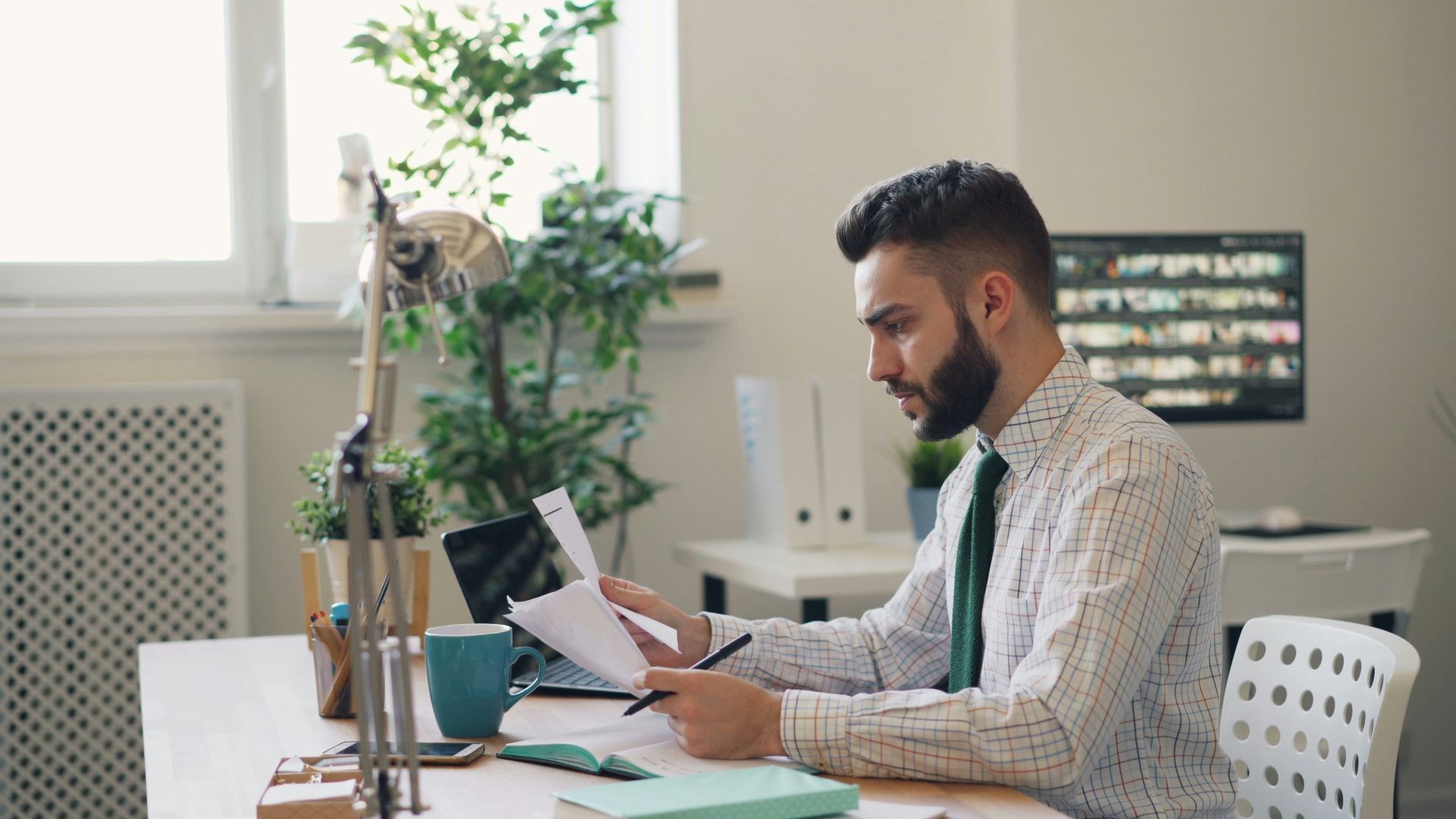 a man sitting at a desk with a laptop and papers