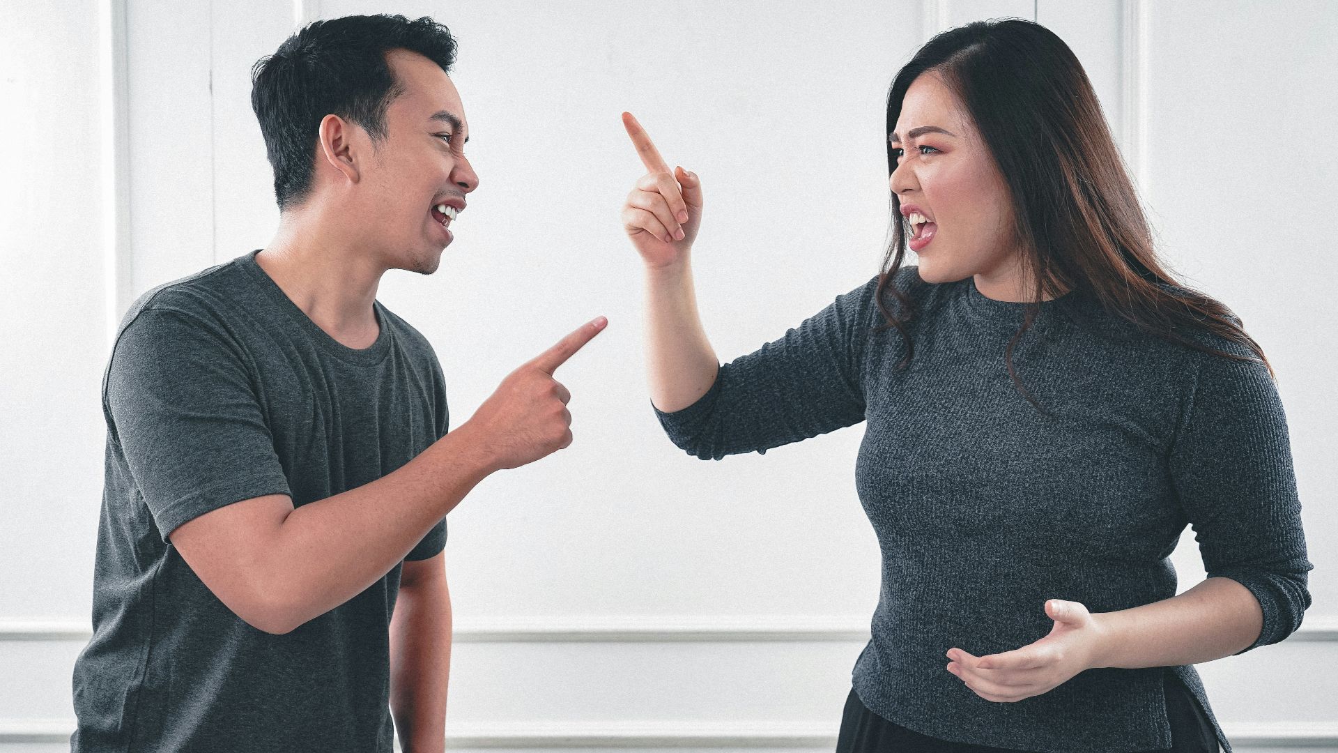 man in gray crew neck long sleeve shirt standing beside woman in black crew neck shirt