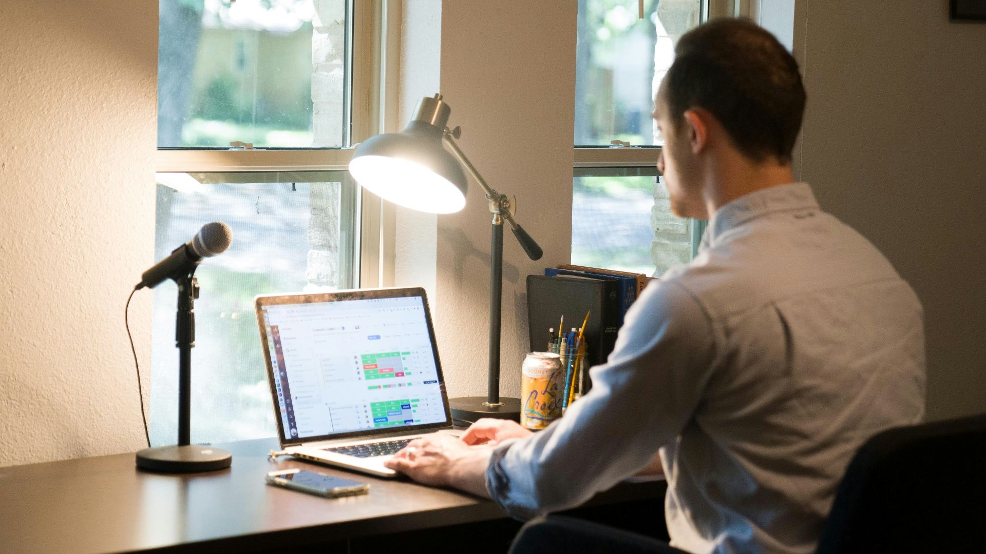 man in white dress shirt sitting on chair using laptop computer