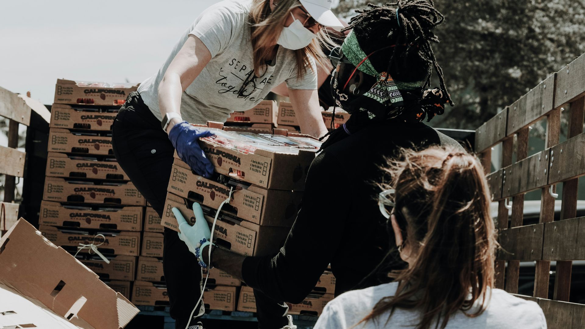 woman in white t-shirt and blue denim jeans sitting on brown cardboard box