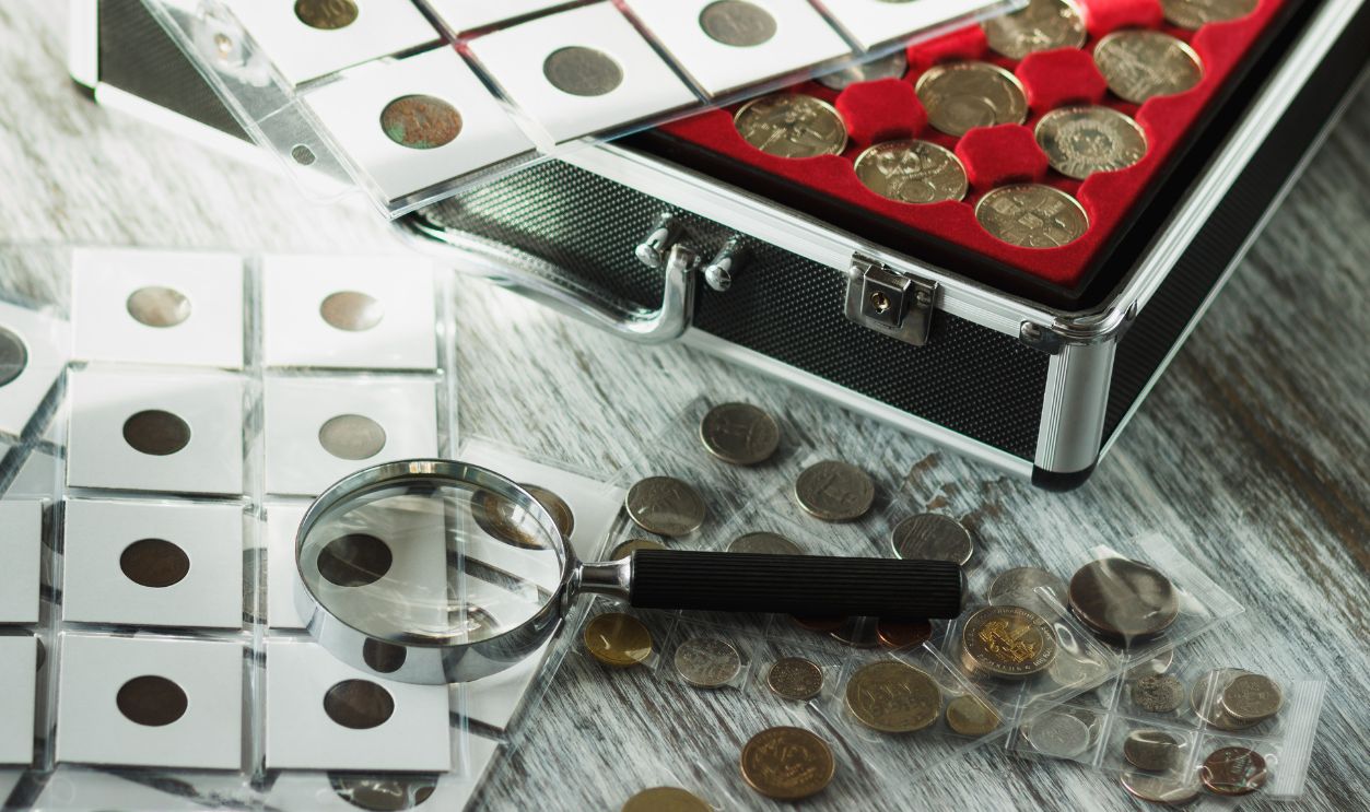 Different collector's coins in the box for coins and a magnifying glass, soft focus background