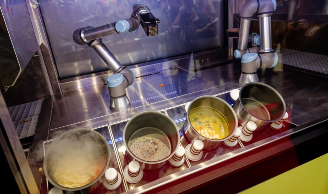 North Rhine-Westphalia, Düsseldorf-Heerdt: Various dishes rotate in pots on hotplates in the autonomous AI cooking robot CA-1. 