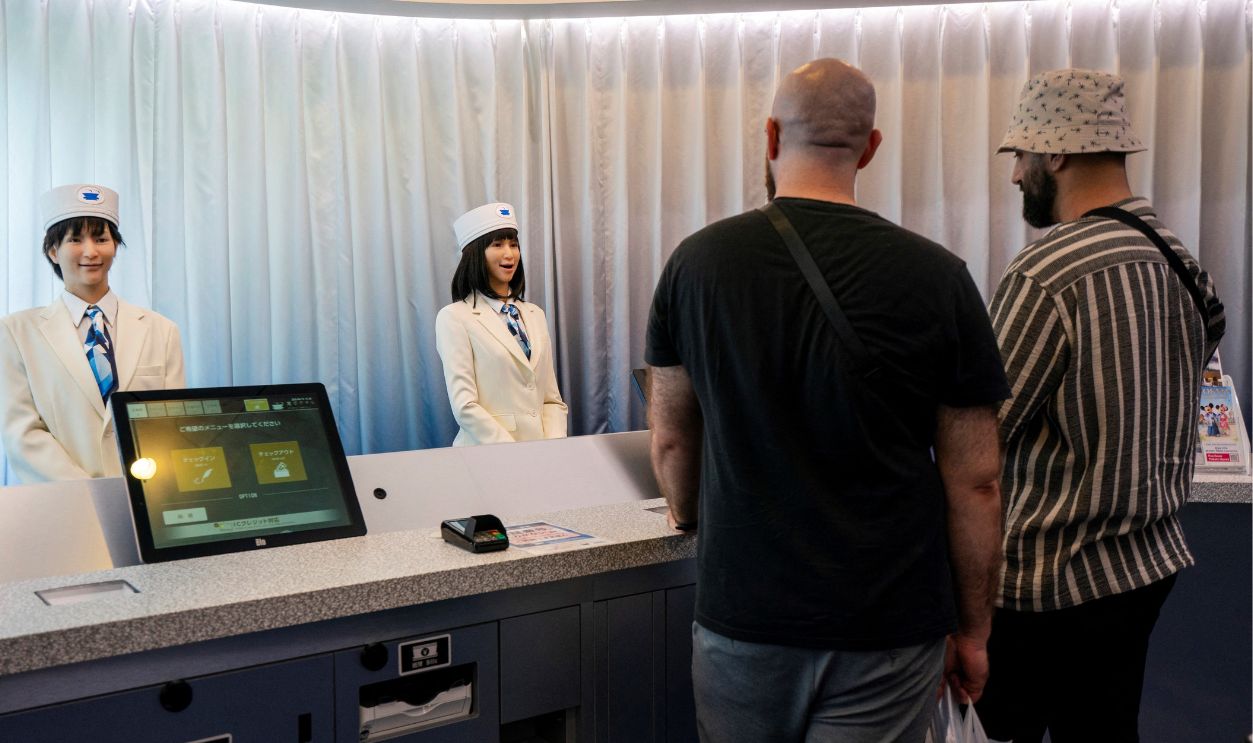 Uniformed humanoid robots welcome guests from the front desk at the Henn-na Hotel Tokyo in Asakusabashi on June 25, 2025. 