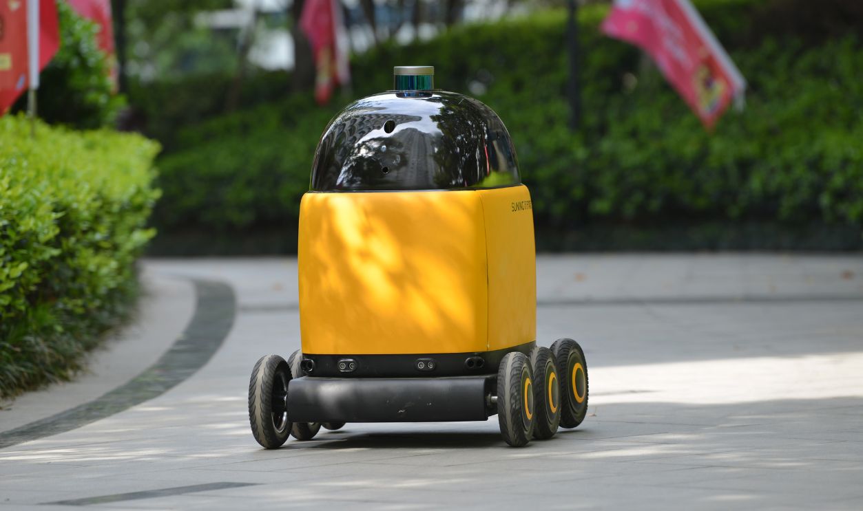 An unmanned robot 'postman' delivers parcels at a pilot community on April 16, 2018 in Nanjing, Jiangsu Province of China. Suning's unmanned robot 'postman' can take elevator to deliver parcels to buyers' door.