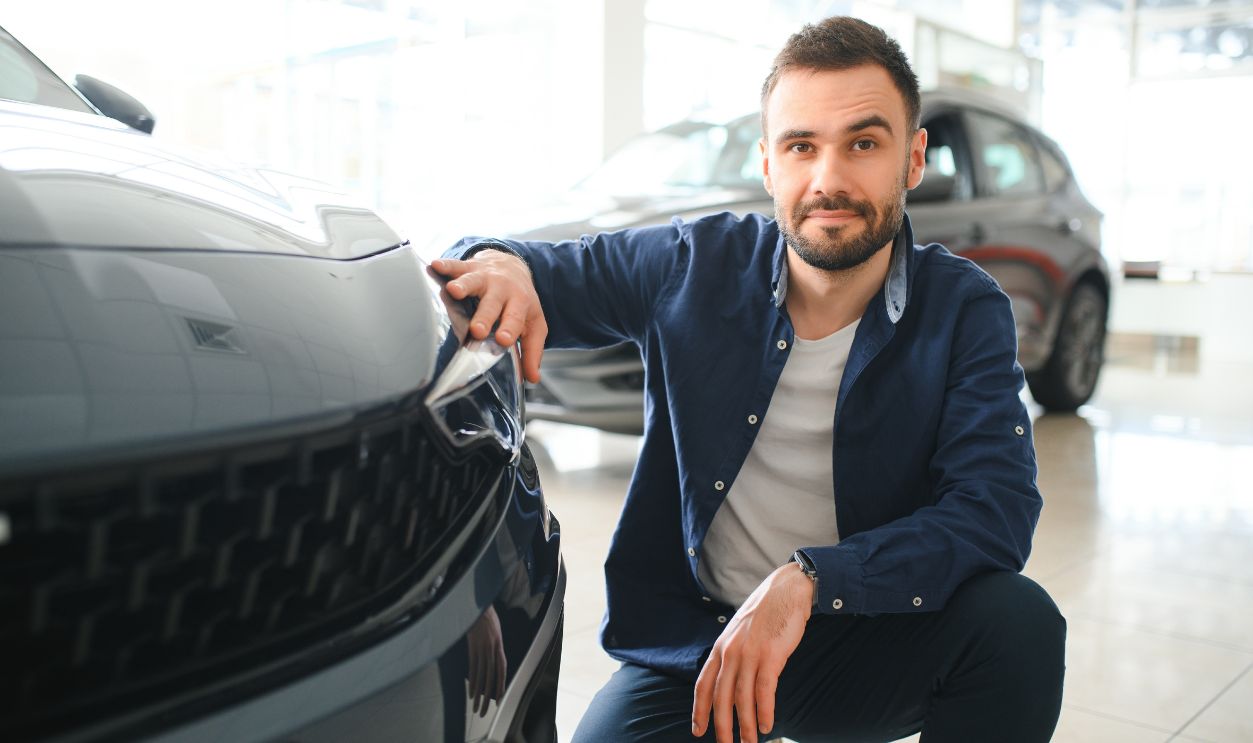 Man customer male buyer client chooses auto wants to buy new automobile.