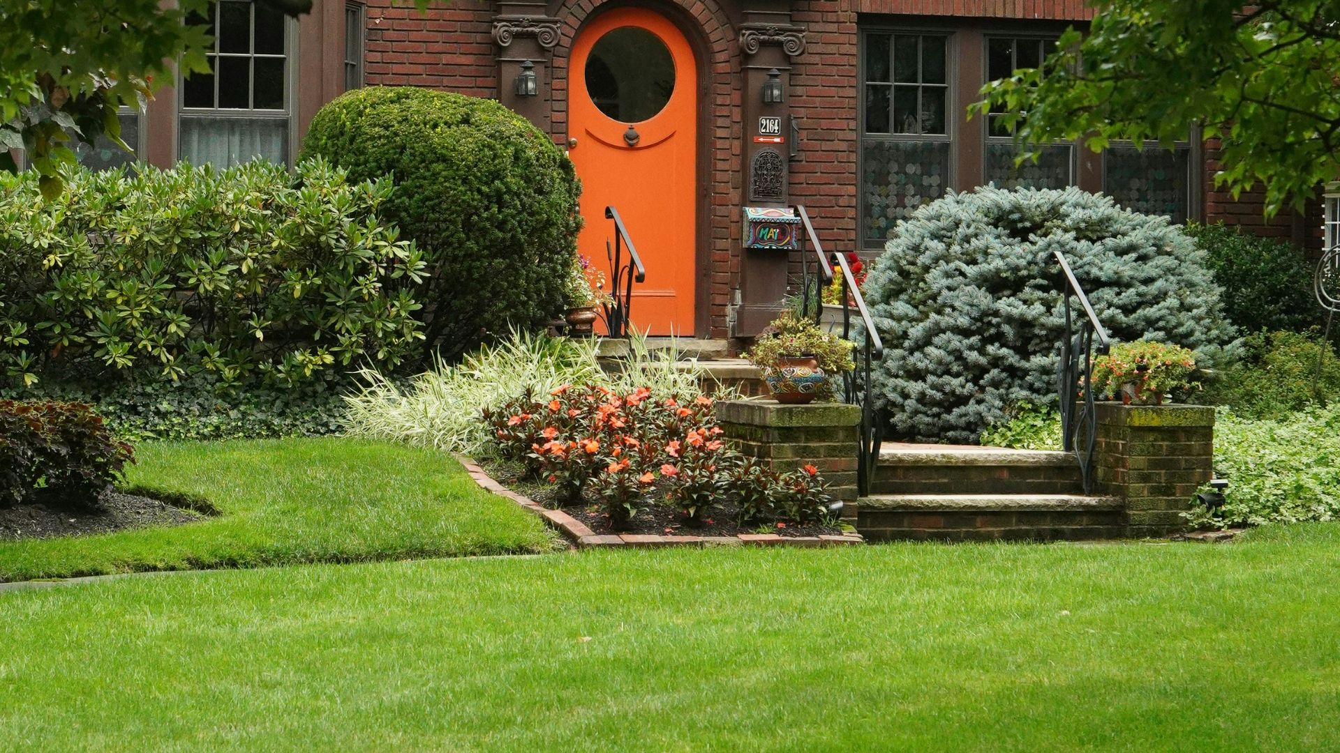 A house with a red door and a green lawn